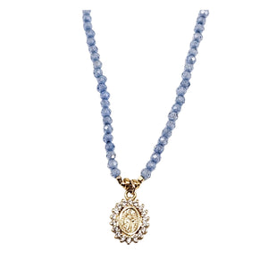 Charm necklace front view with pale violet blue beads and ornate gold flower pendant