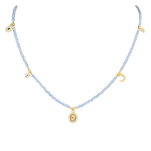 Charm necklace close-up with pale violet blue beads and small gold charms along chain