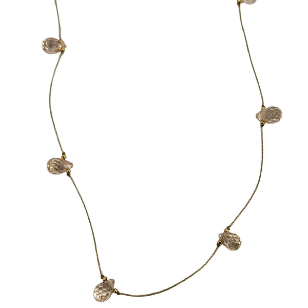 Gold-tone delicate necklace with peach teardrop faceted gemstones on thin chain