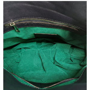 Quilted leather shoulder bag interior with green fabric lining and zipper edge