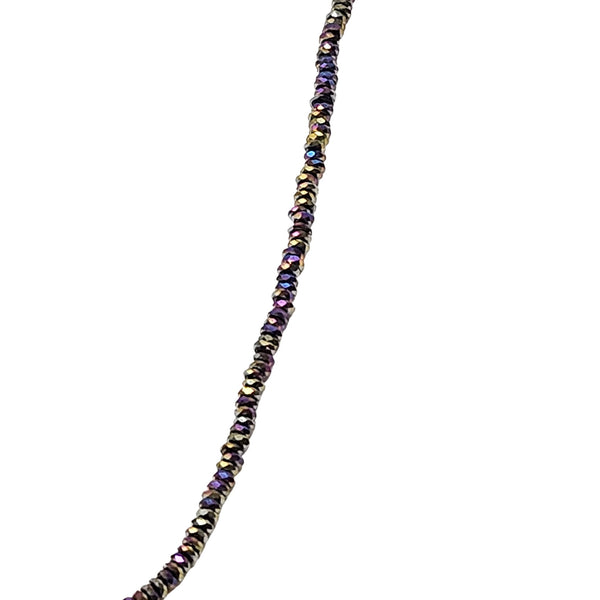 Close view of dark multicolor beaded strand choker with gold-toned spacers along the chain