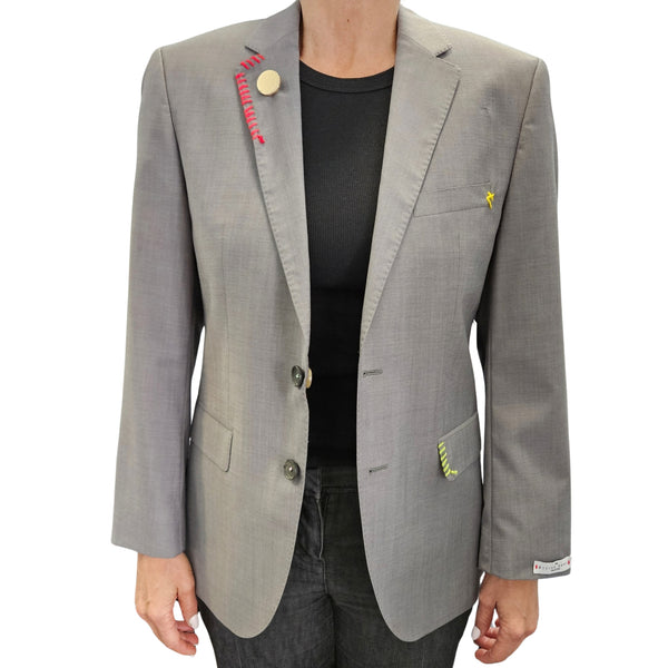 Grey single-breasted blazer with notch lapels, front buttons, colorful sleeve patches
