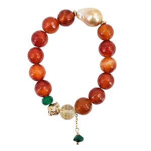 Red bead stretch bracelet with gold spacer and green bell charm