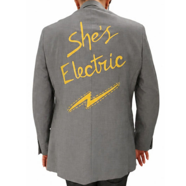Grey blazer with 'She's Electric' yellow graphic on back