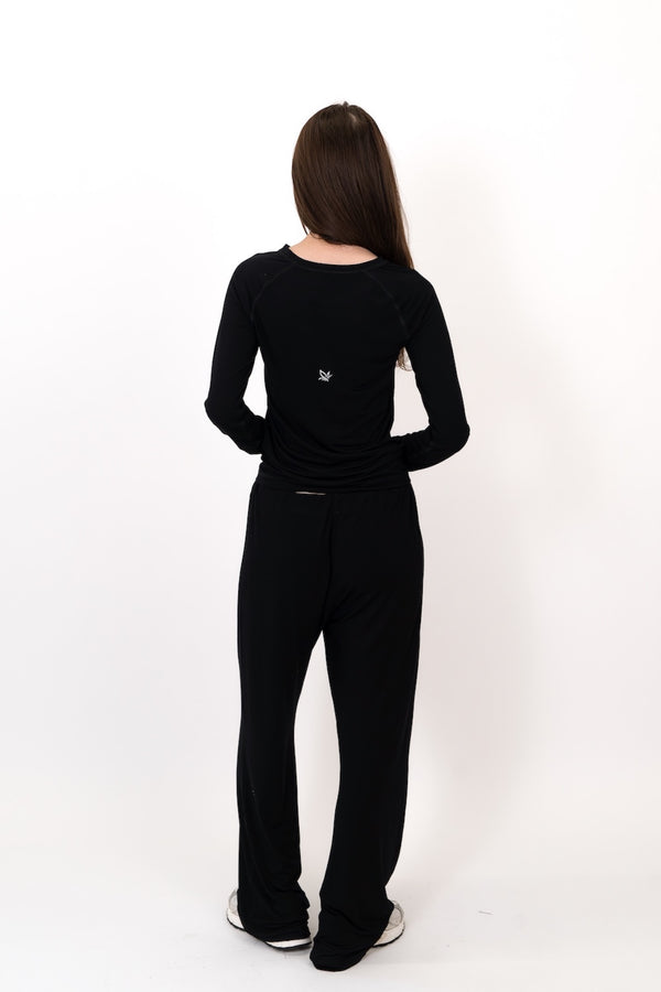 Black flow pants from back view, full length with elastic waist
