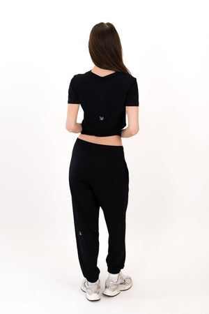 Black sweatpants, back view, relaxed legs with elastic ankle cuffs