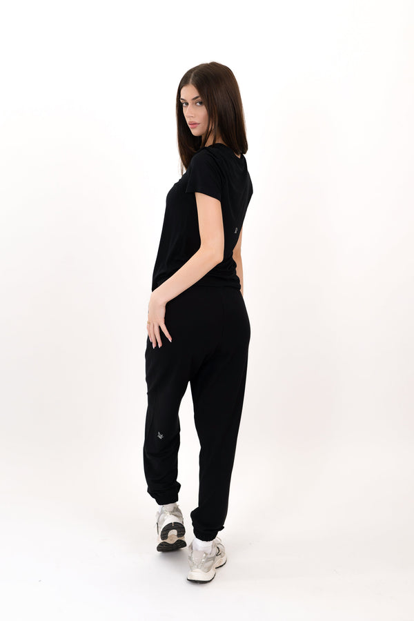 Black sweatpants, side view, relaxed jogger style with elastic ankle cuffs