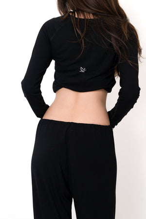 Black long-sleeve crop top with small chest logo