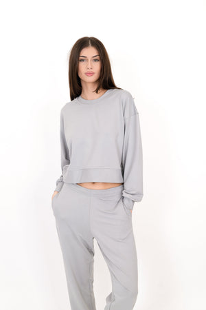 Gray crew neck pullover with long sleeves and knotted drawstring waist hem.