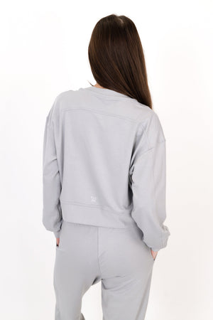 Gray crew neck pullover, back view, long sleeves with drawstring waist hem.