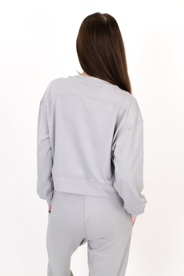Gray crew neck pullover, back view, long sleeves with drawstring waist hem.