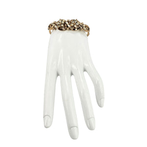 Gold rhinestone bracelet on display hand with arched band and crystal flower details