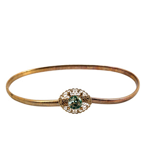 Gold-tone snake chain bracelet with filigree clasp and green gemstone