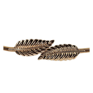 Gold leaf buckle belt close-up, braided leaf emblem across metal bar