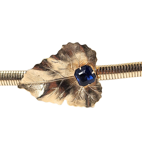 Close-up: gold tone leaf snake clasp with blue gemstone
