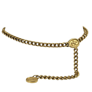 Gold chain belt with round medallion clasp, hanging coin tag, and long linked ends