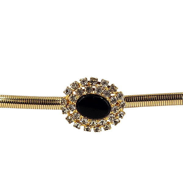 Gold belt buckle with black oval cabochon surrounded by rhinestone cluster