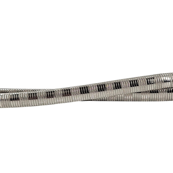 Close-up of silver snake chain belt with black rectangular accent pattern