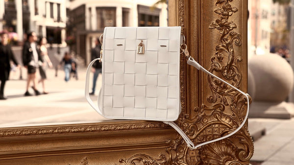 White woven leather crossbody bag with gold lock clasp and crossbody strap