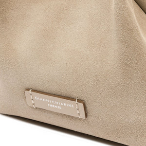 Close-up of nude mini hobo bag front logo patch on textured leather