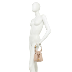 Off-white leather bucket bag on mannequin with drawstring top and short handle
