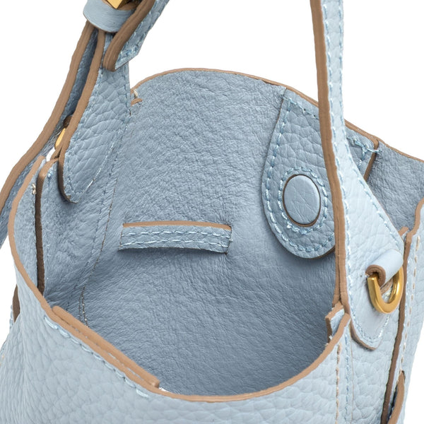 Light blue leather bucket bag front pocket with stitched oval snap detail