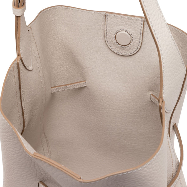 Off-white leather bucket bag interior with side pocket and stitched top edge