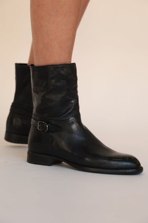 Black leather mid-calf boots with side zip, buckle strap, and low block heel