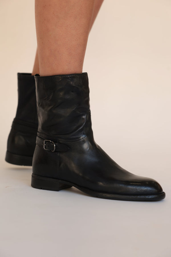 Black leather mid-calf boots with side zip, buckle strap, and low block heel