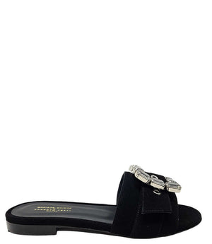 Black suede slide sandal with jeweled buckle and low rubber sole