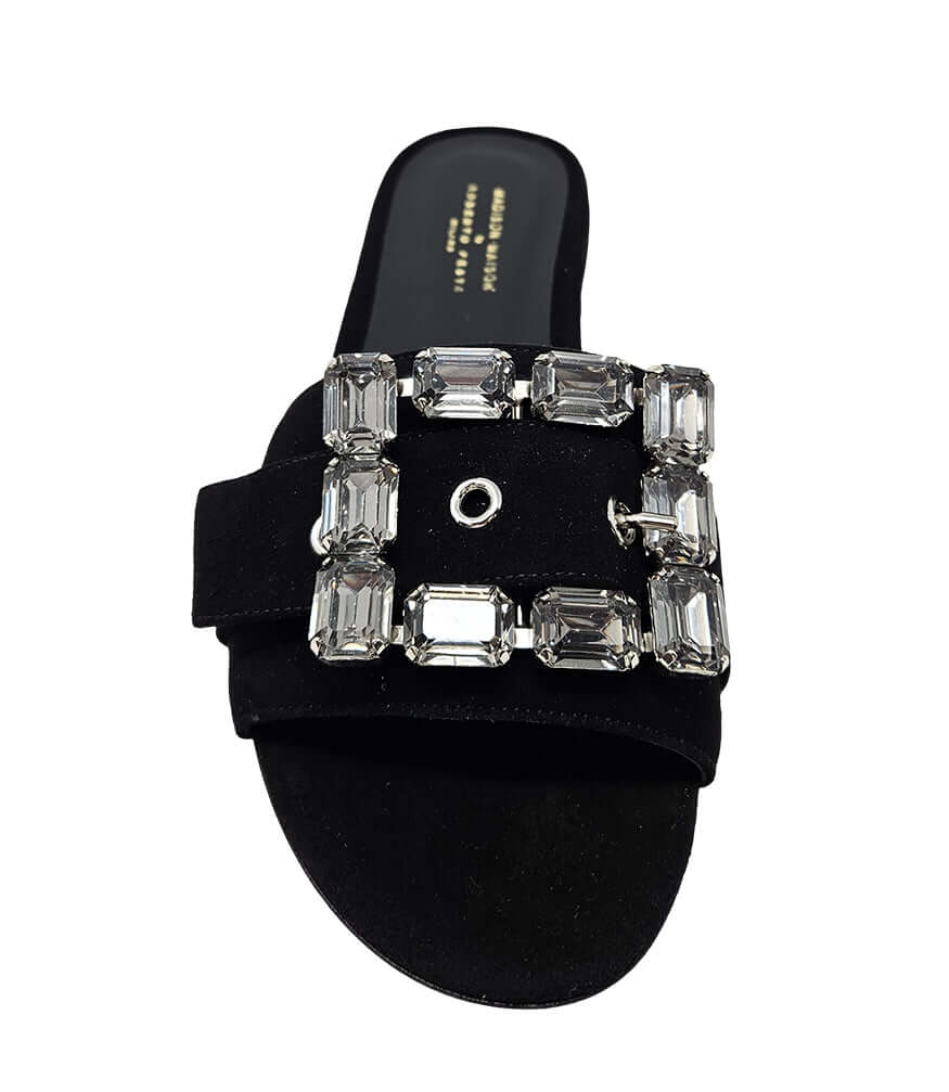 Black suede slide sandal with jeweled buckle and low rubber sole