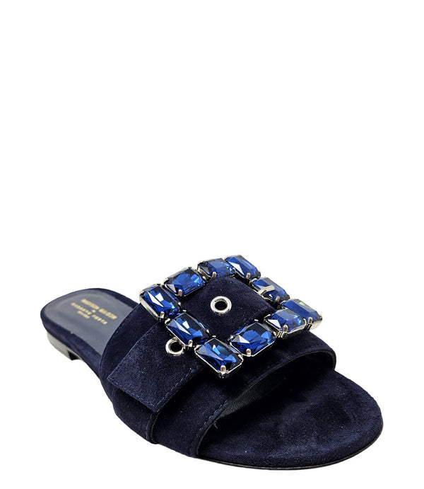 Navy suede slide sandal with large blue jeweled buckle and open toe