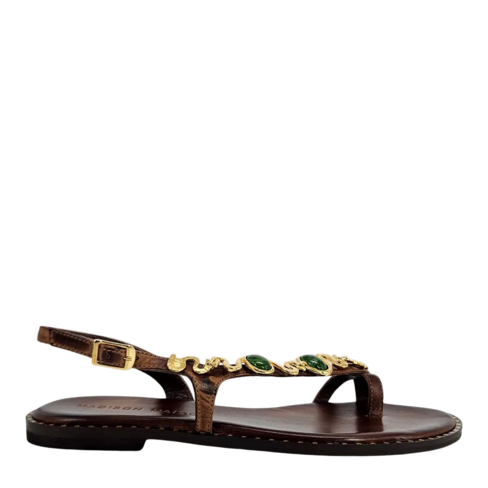 Chocolate brown leather flat sandal with gold serpent strap and green gem accents