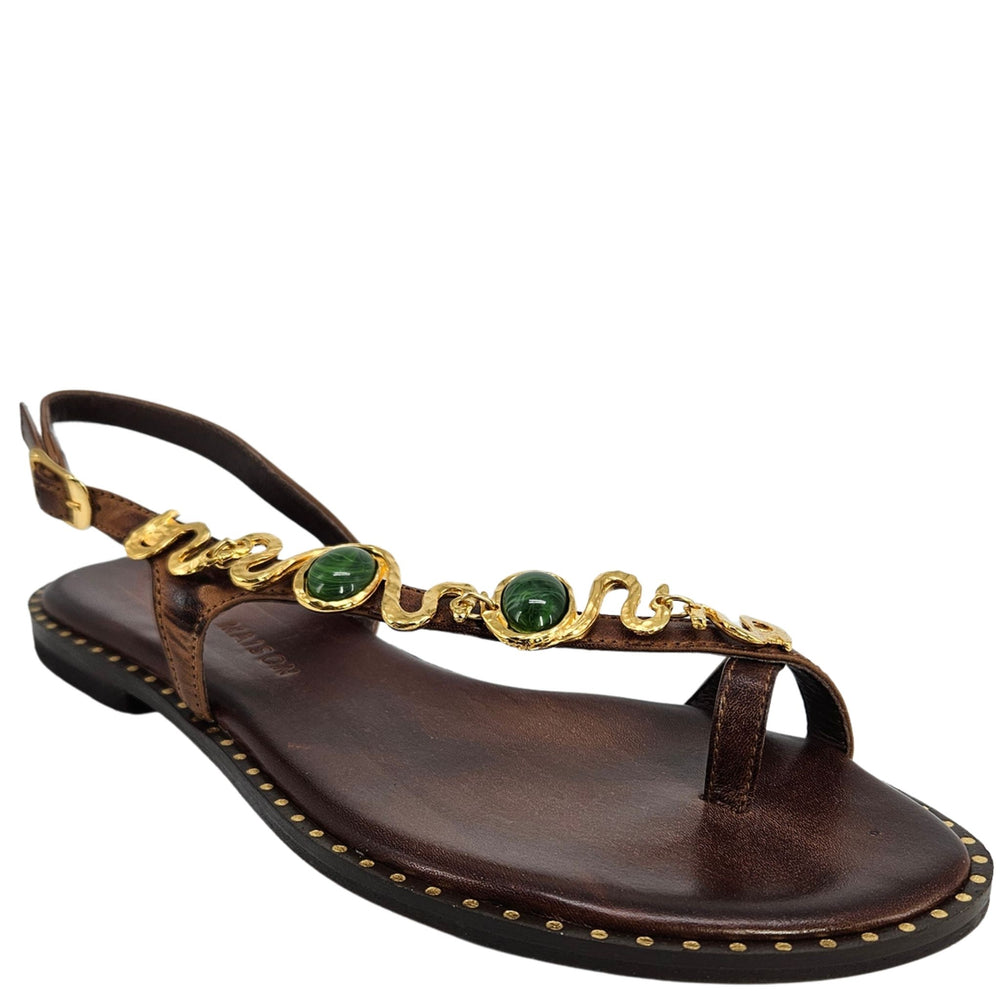 Chocolate brown leather flat sandal with gold serpent strap and green gem accents