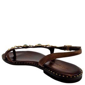 Back view of dark brown leather flat sandal with gold serpent strap and green stones
