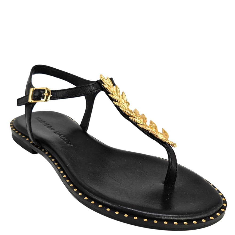 Black flat thong sandal with gold leaf strap detail, buckle, and studded sole