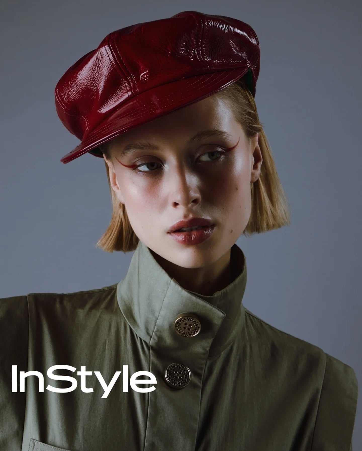 Red leather motorcycle hat on model, curved brim and stitched panels