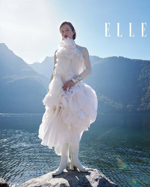 White tall boot on model with gold ankle hardware and low block heel