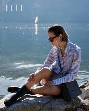Black leather mid-calf boots with red back stripe detail worn outdoors