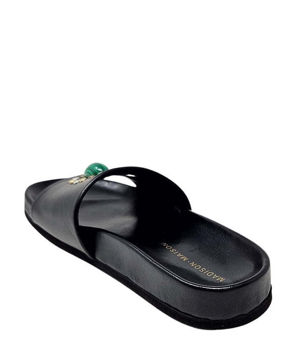 Black open-toe slide sandal, side profile with green gem ornament on strap