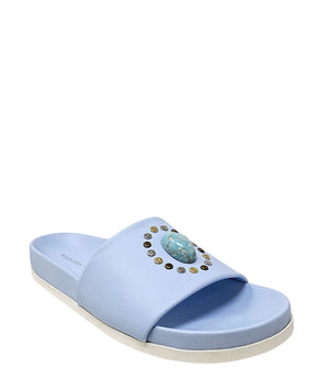 Sky blue open-toe slide sandal, angled view; oval jewel with gold studs on strap