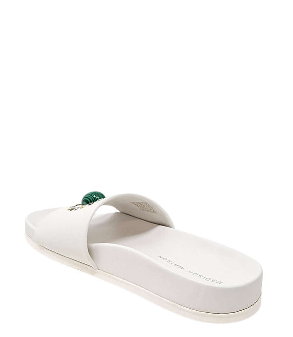 White open-toe slide sandal with padded strap and cushioned sole, green ornament