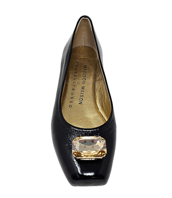 Black jeweled ballet flats with gold gem on toe, interior lining visible