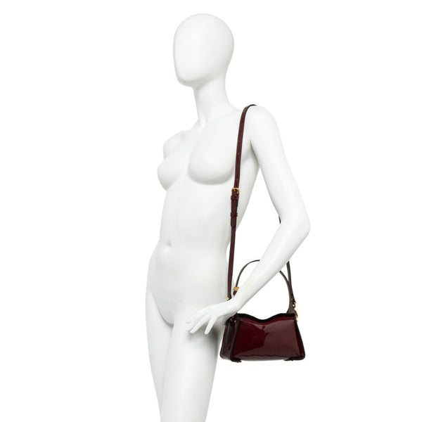 Dark berry patent-leather crossbody handbag with thin strap and gold-tone hardware