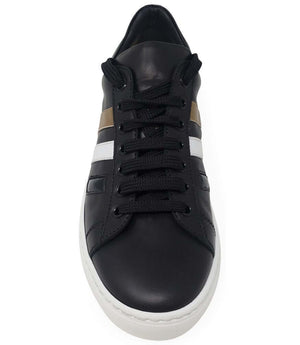 Black leather sneaker front view with gold panel and white 3-stripe detail, white sole