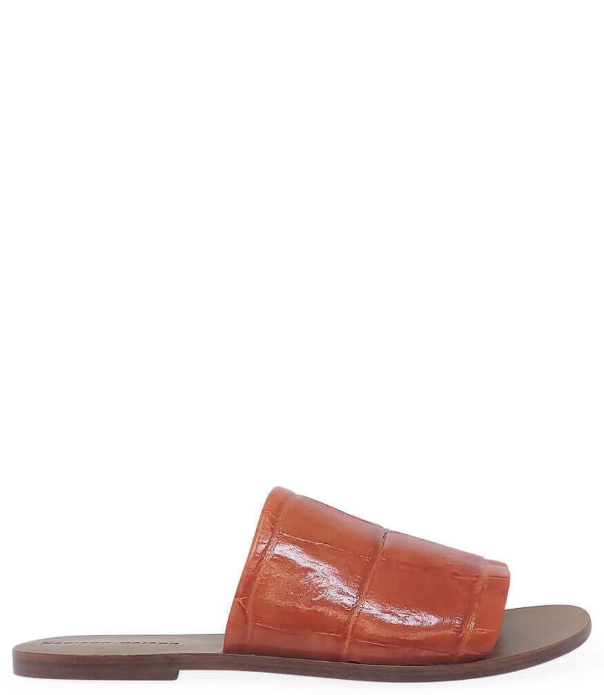 Orange open-toe slide sandal with flat sole and wide crossover vamp