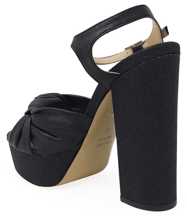 Black glitter platform heel sandal with twisted bow at front and ankle strap